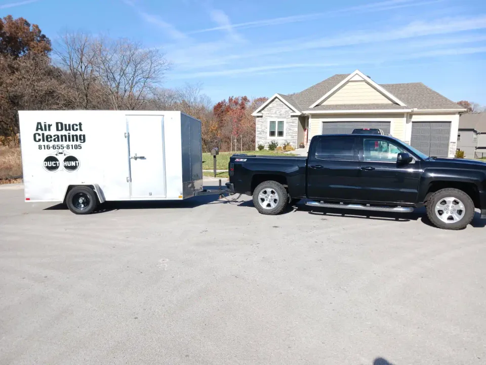 Duct Hunt truck and branded air duct cleaning trailer outside a Kansas City home
